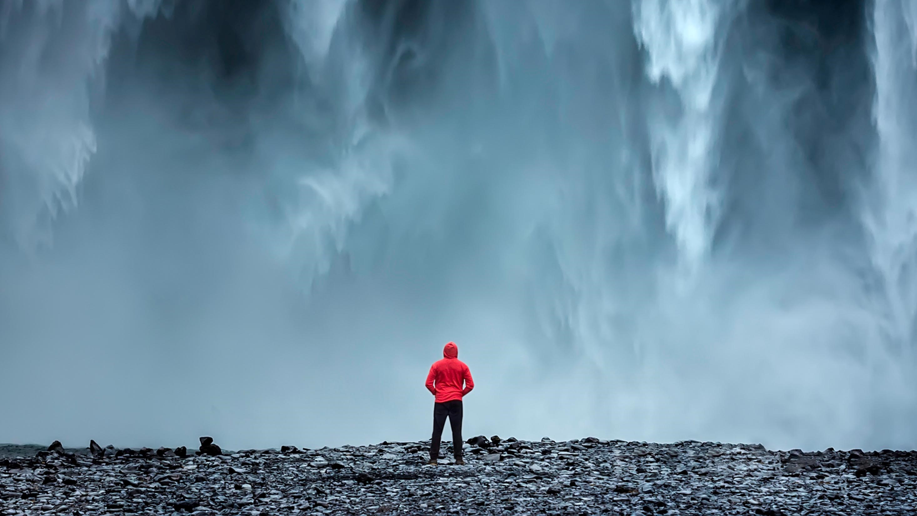 a men in front of a waterfall