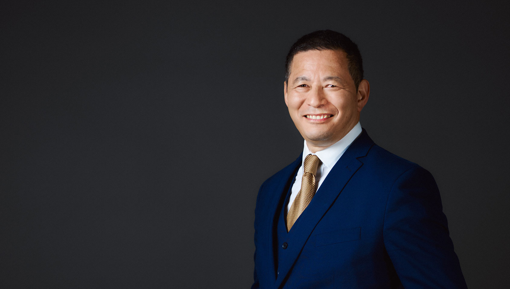 A men in a blue suit smiling while presenting BNP Paribas Wealth Management Podcast