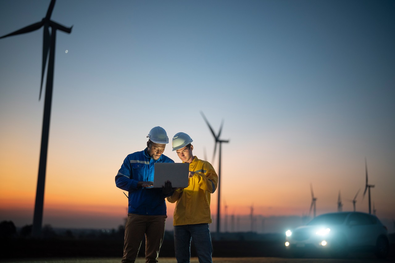 Workers with windturbines at the back