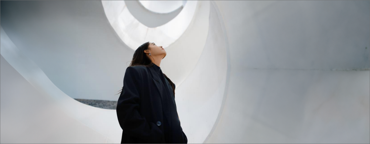 Une femme regardant en l'air, entourée d'escaliers