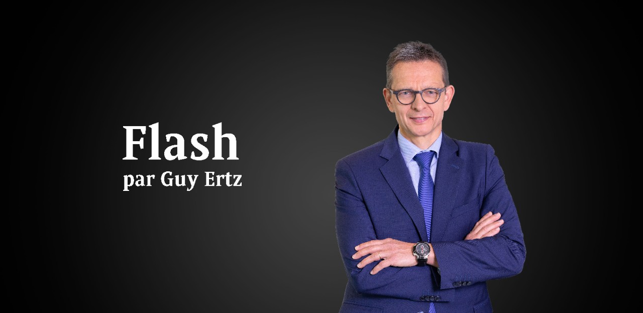 Flash par Guy Ertz Un homme en costard bleu accompagné d'un titre à sa gauche