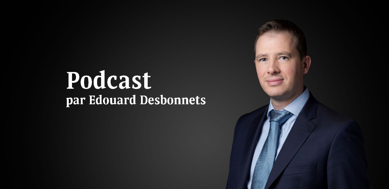 Un homme souriant habillé en costume bleu avec l'inscription Podcast