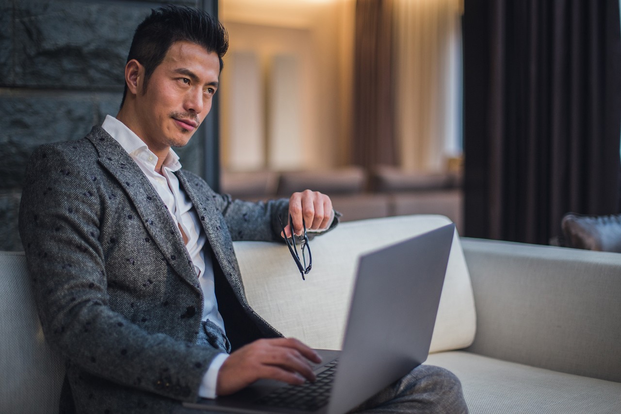 Businessman sitting on the sofa and using laptop